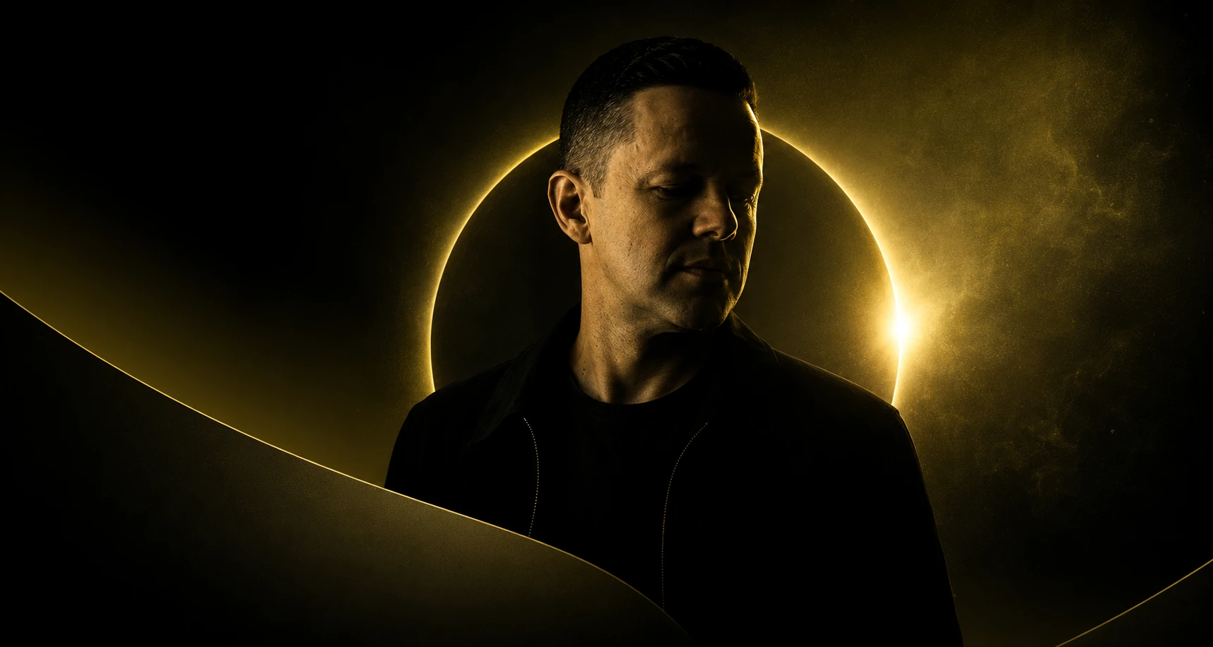 Dario Nunez in a dark portrait with a warm solar eclipse halo behind him